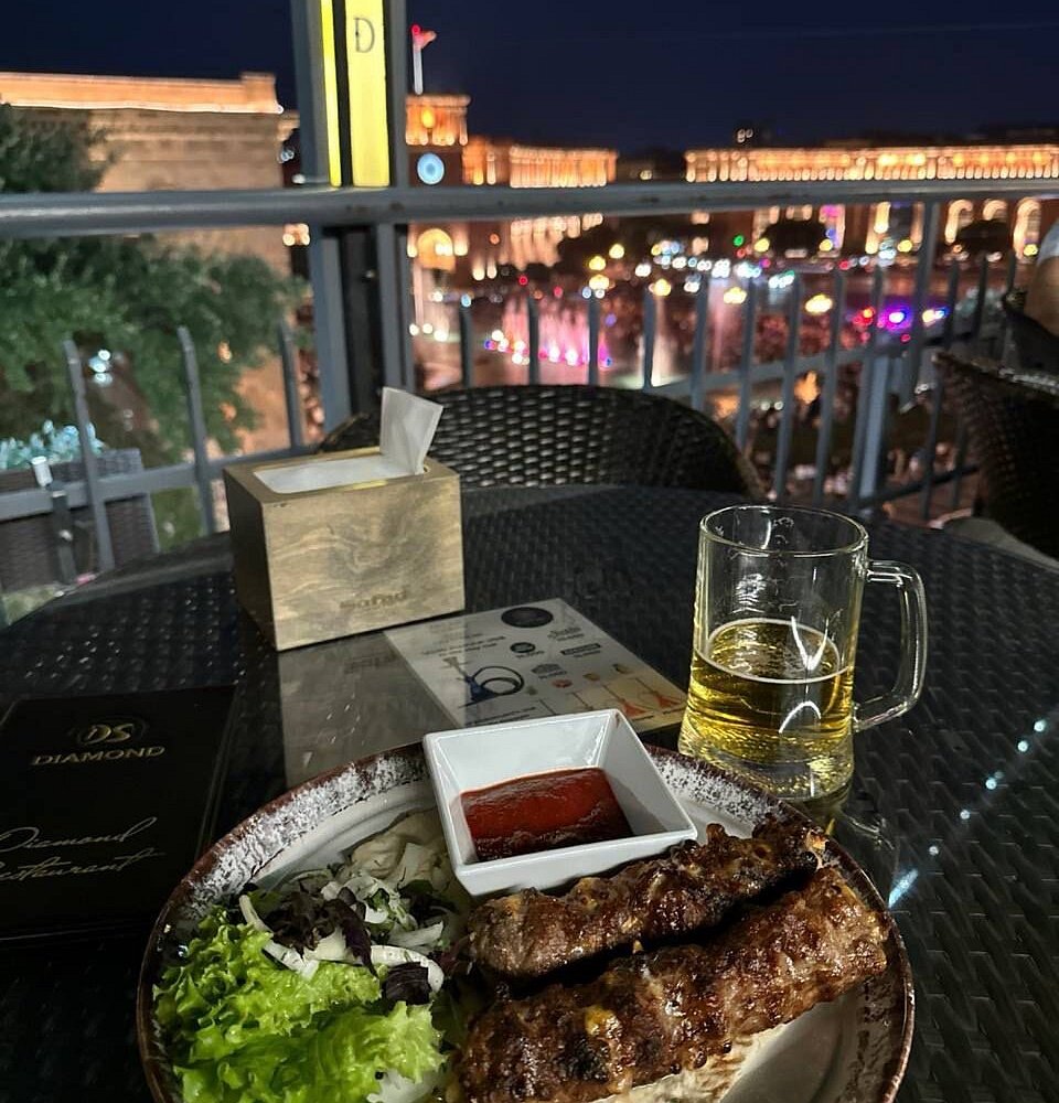 Սեղան Diamond Restaurant-ում՝ ուտեստներով և հրապարակին նայող տեսարանով